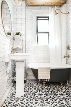 a bathroom with black and white tile flooring and a bathtub next to a sink