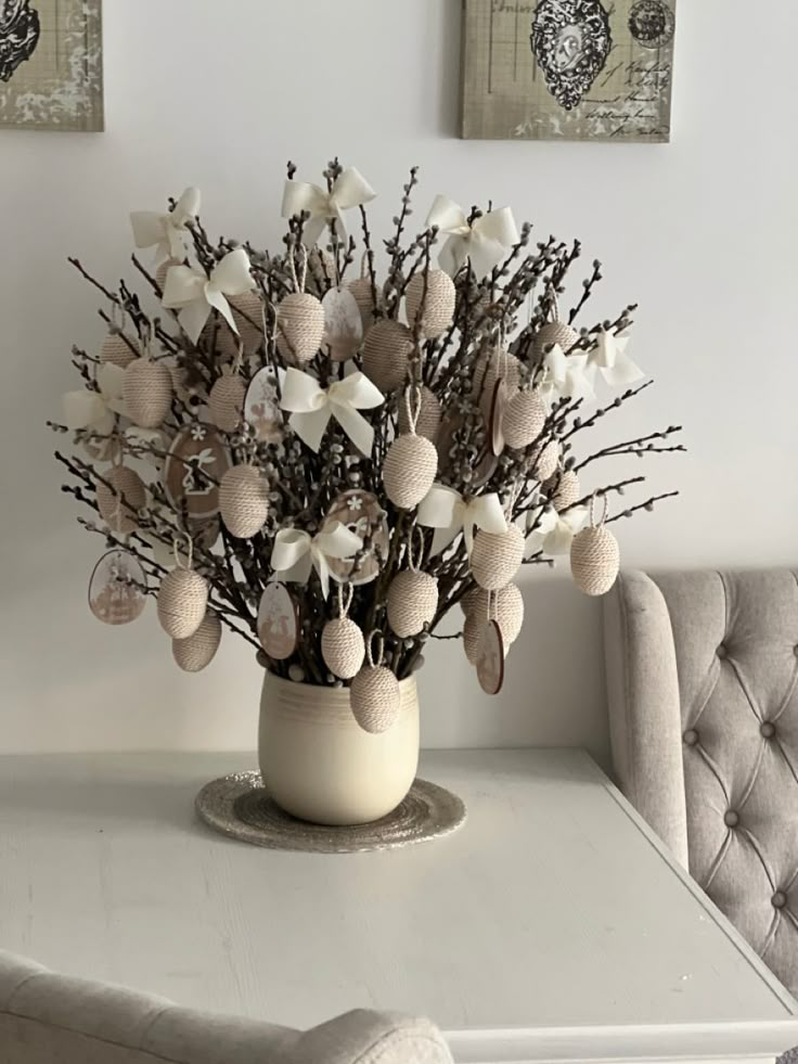 a vase filled with flowers sitting on top of a white table next to a chair