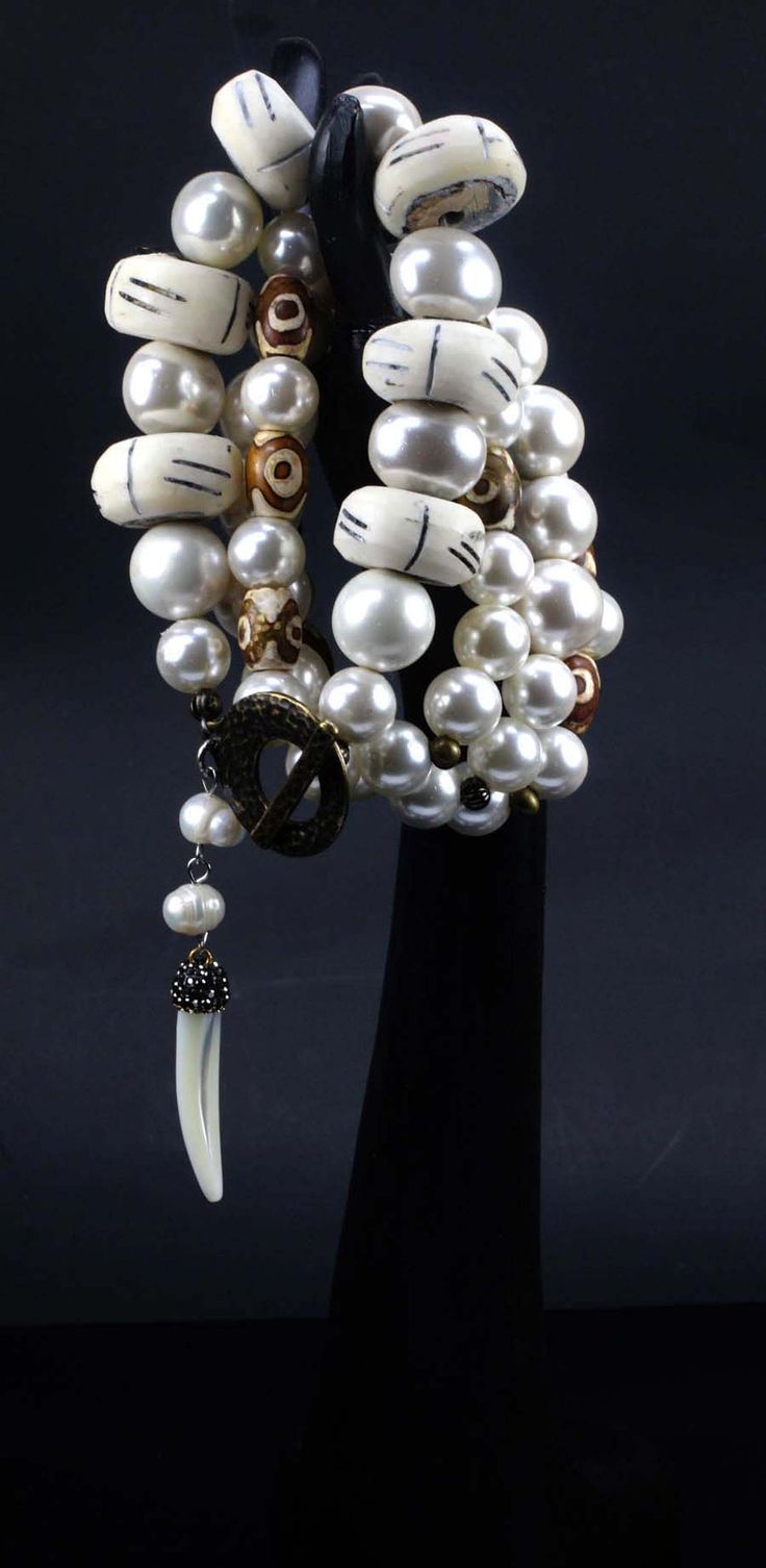 Bohemian, 4-strand, statement bracelet created from African bone beads, Shell Pearls and Agates with a mother of pearl dangle and toggle clasp. Eye catcher? Most definitely, yes! Bracelet fits approx. 7 1/2" - 8" wrist. Bracelet includes 3 stretch bracelets and 1 bracelet with a toggle clasp. Your bracelet arrives in a beautiful, black embossed, cotton-lined box. These stunning African bone beads are from Kenya and are usually made from cow or water buffalo bone that has been bleached and then p Bohemian Single Strand Bracelets With Round Beads, Bohemian Bracelets With Single Strand Round Beads, Unique Hand Wrapped Multi-strand Bracelets, Unique White Bracelets With Large Beads, Unique Multi-strand Beaded Bracelets, Unique White Bracelet With Large Beads, Unique Hand-strung Multi-strand Jewelry, Unique Multi-strand Hand Wrapped Bracelets, White Multi-strand Bracelets For Jewelry Making