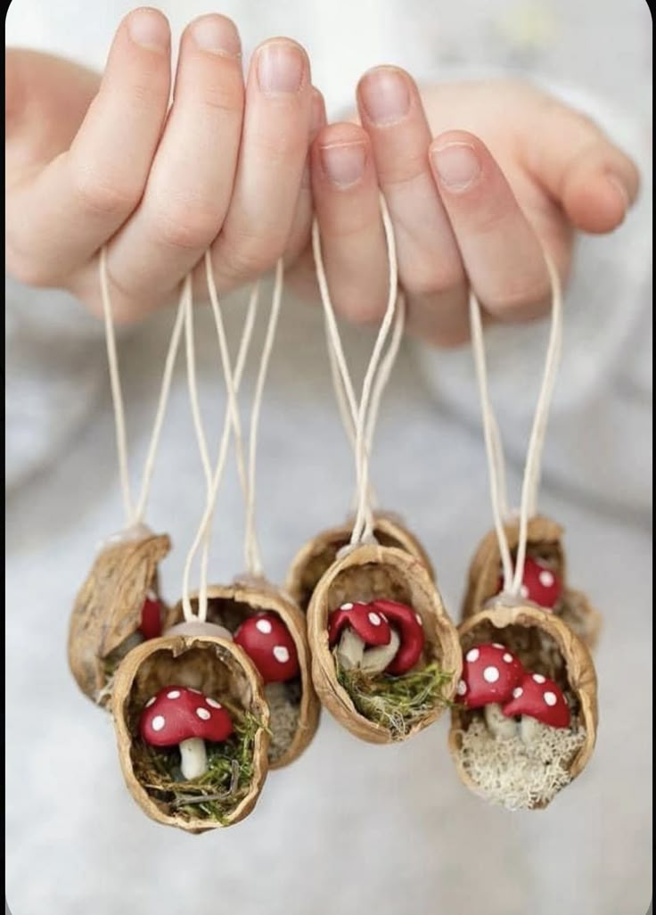 four small mushrooms are hanging from twine