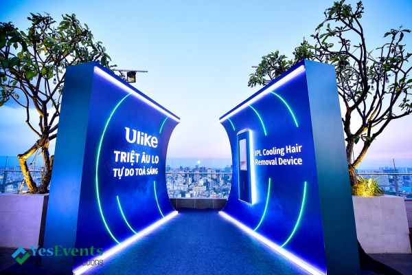 an entrance to the top of a building with blue lights and trees in the background