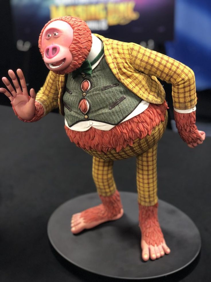 a figurine of a monkey wearing a suit and holding his hand out to the side