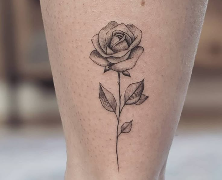 a small rose tattoo on the leg