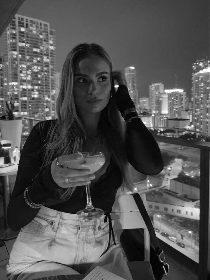 a woman sitting at a table with a martini in her hand