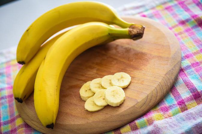 some bananas are sitting on a cutting board