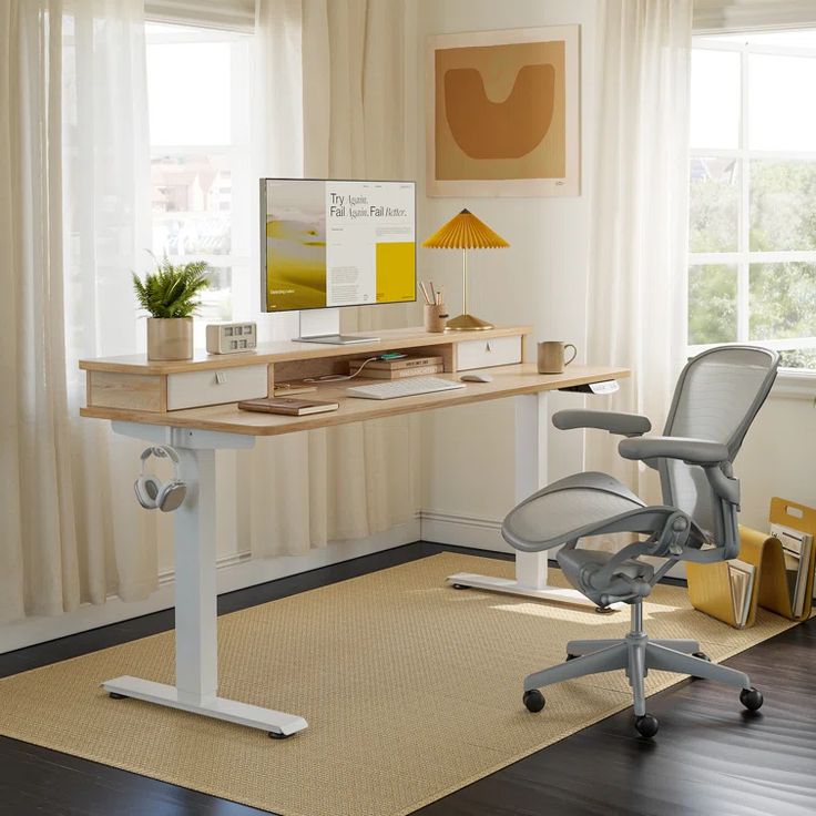 an office desk with a computer on it in front of a window and a rug