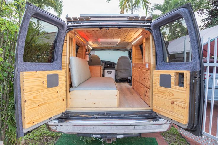 the back end of an empty van with wood paneling and leather seats in it