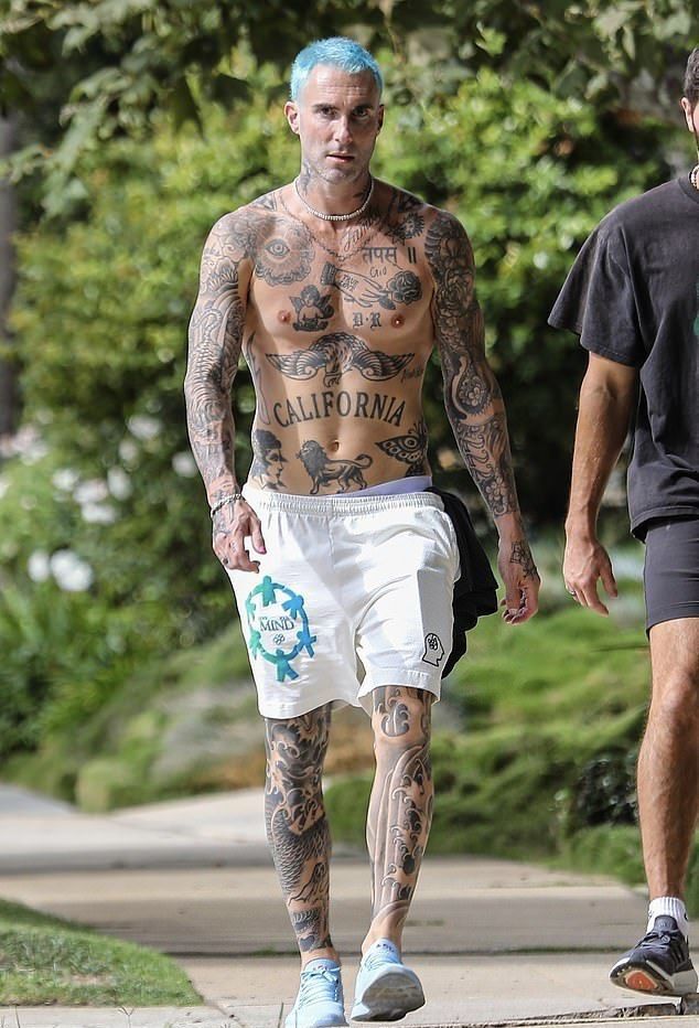 tattooed man walking down the sidewalk with his friend