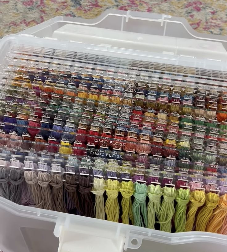 a plastic container filled with lots of different colored thread