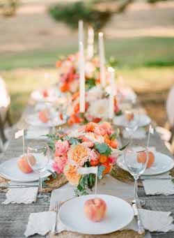 the table is set with peaches, white plates and place settings for an elegant dinner