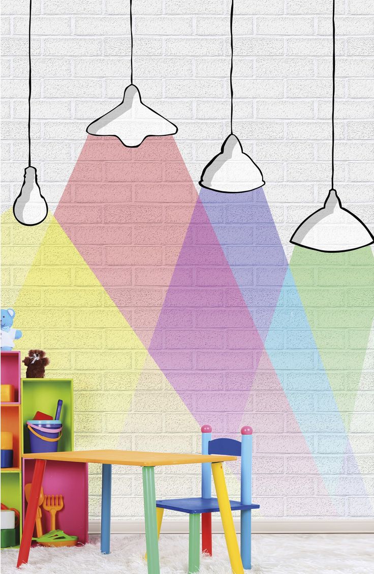 three lamps hanging over a table in front of a colorful wall