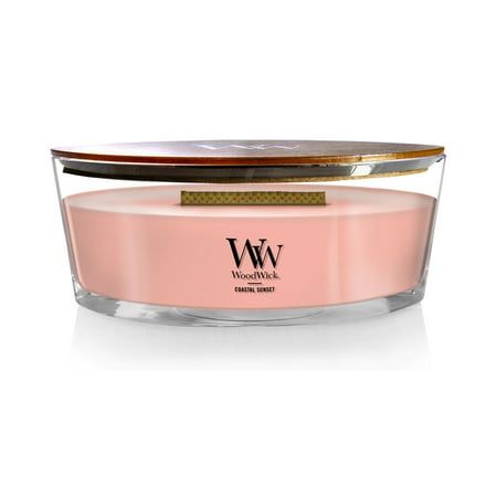 a pink candle in a glass container with a gold lid on the top and bottom