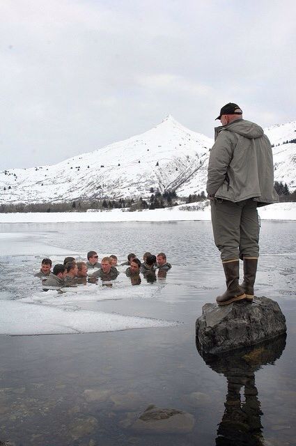 a man standing on top of a rock in the middle of a body of water