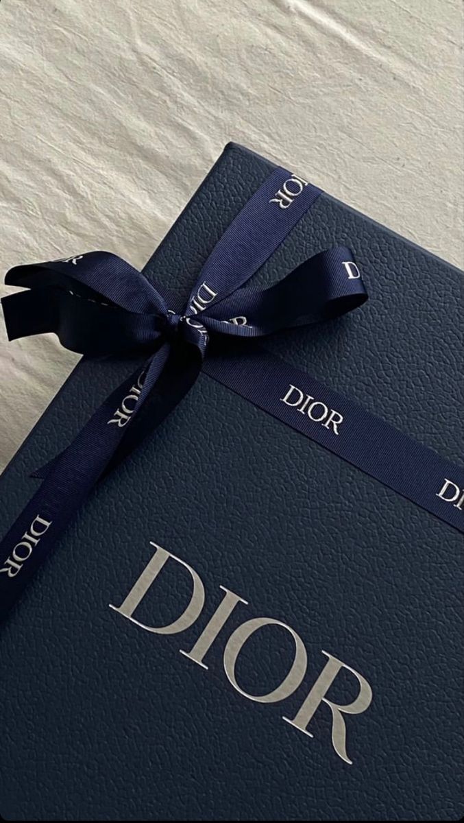 a black book with a blue ribbon tied around it on top of a white sheet