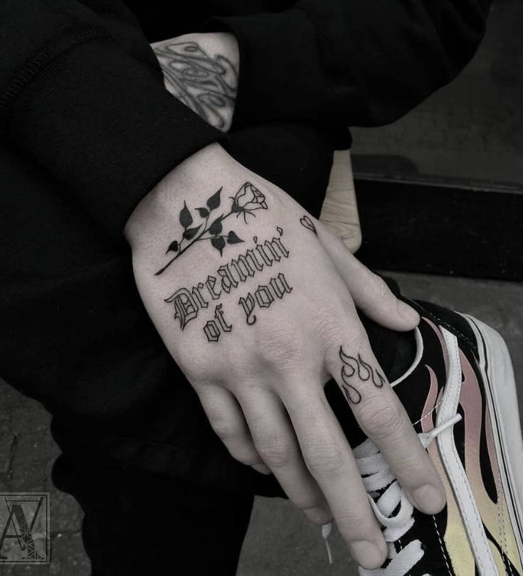 a person with a black and white tattoo on their hand