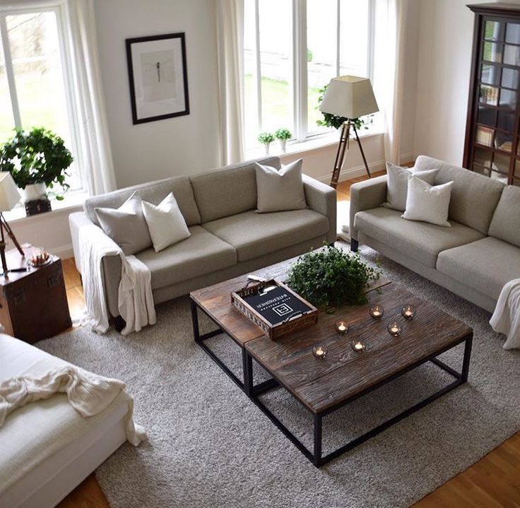 a living room with two couches and a coffee table in front of large windows