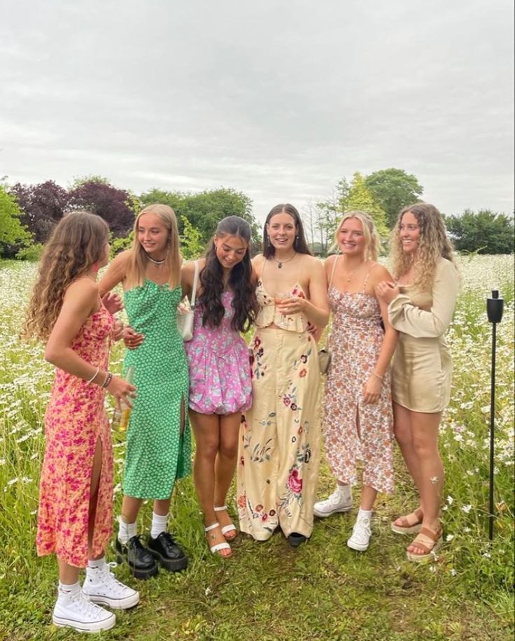 a group of young women standing next to each other on a lush green grass covered field