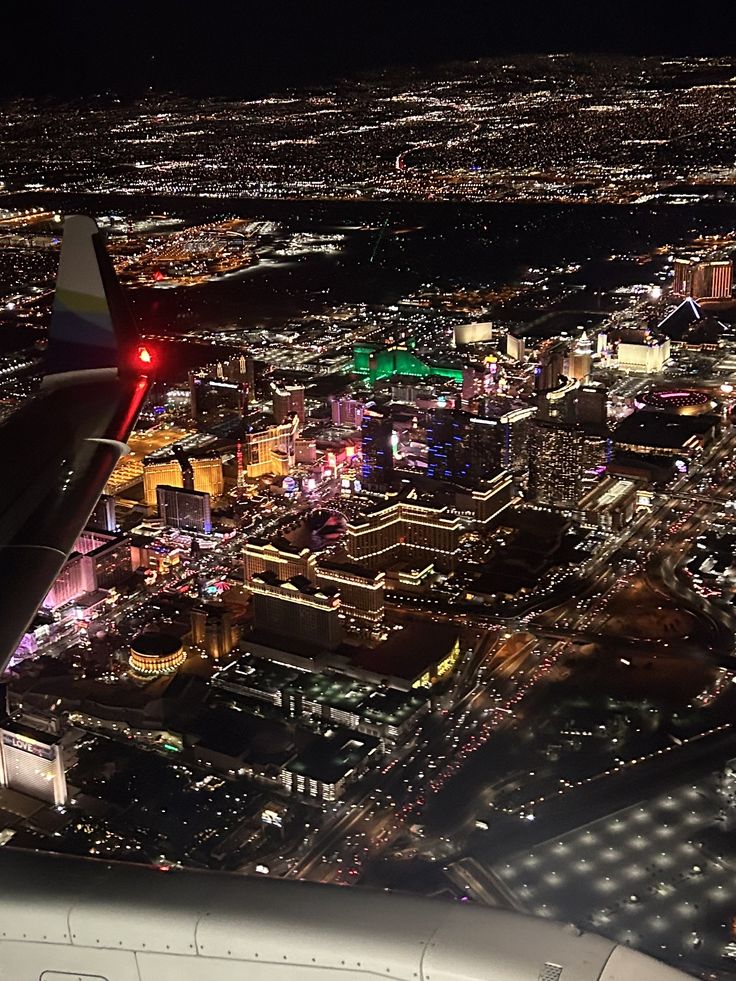 an airplane wing flying over a city at night