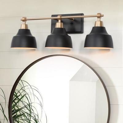 a bathroom with a mirror and three lights on the wall next to a potted plant