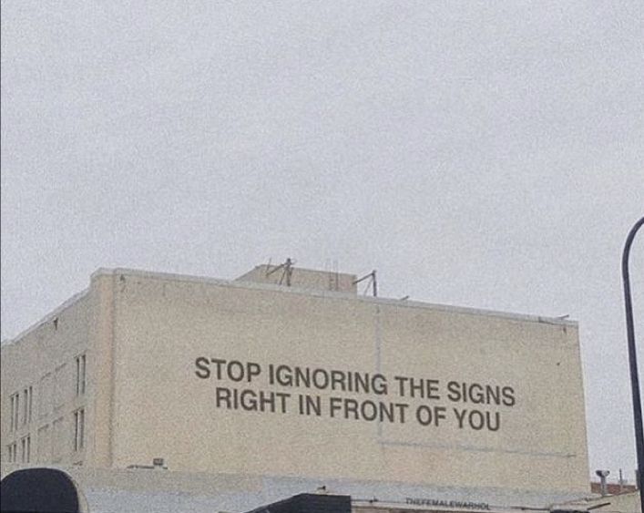 an advertisement on the side of a building reads stop ignoring the signs right in front of you