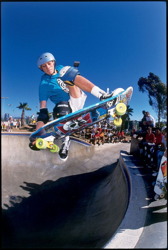 a man riding a skateboard up the side of a cement ramp at a skate park