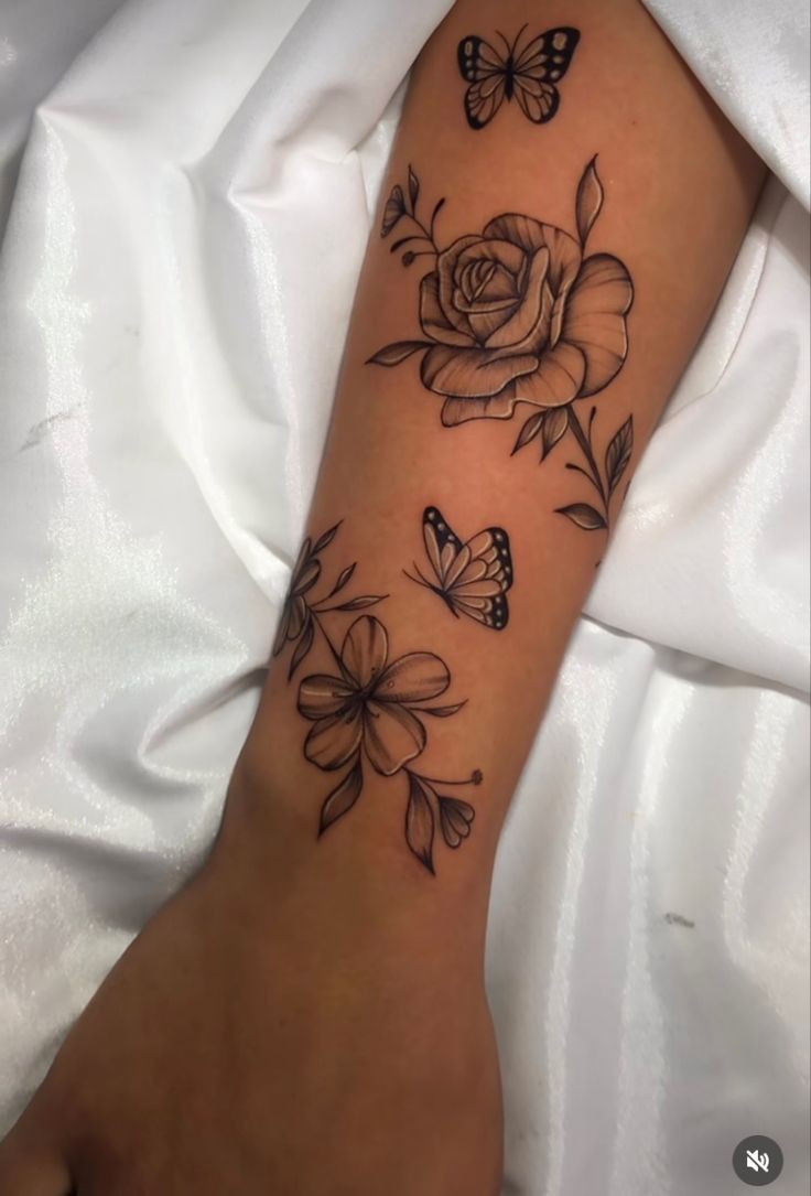 a woman's arm with flowers and butterflies on it