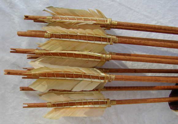 several arrows are lined up next to each other on a white cloth covered tablecloth