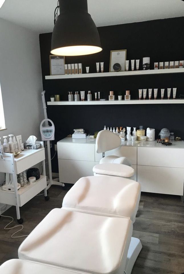 a salon with white chairs and black walls