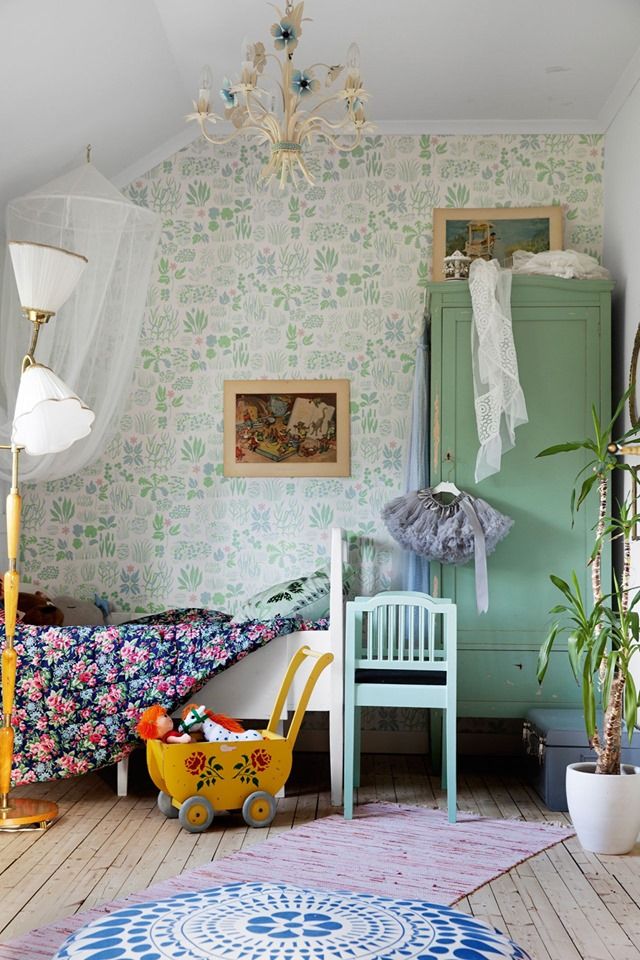 a small child's bedroom with floral wallpaper