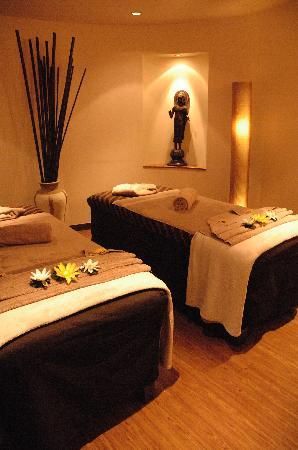 two massage beds with towels and flowers on them