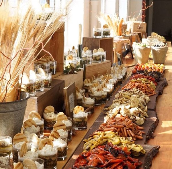 a long table filled with lots of different types of food on top of wooden boards