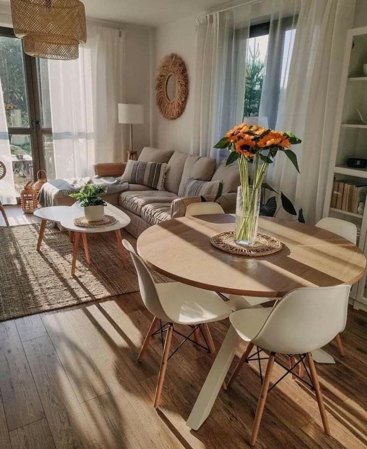 a living room filled with furniture and a wooden table in front of a large window