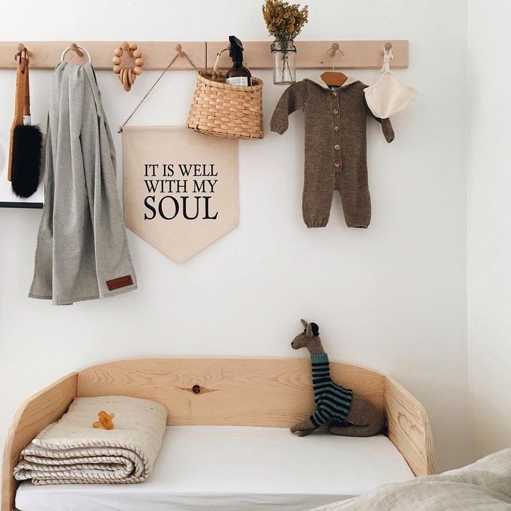 an instagram photo of a baby's room with clothes hanging on the wall