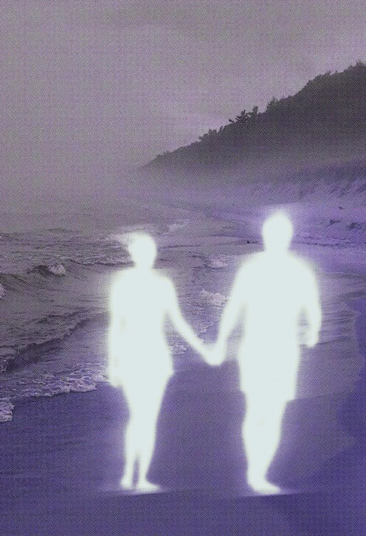 two people holding hands on the beach at night