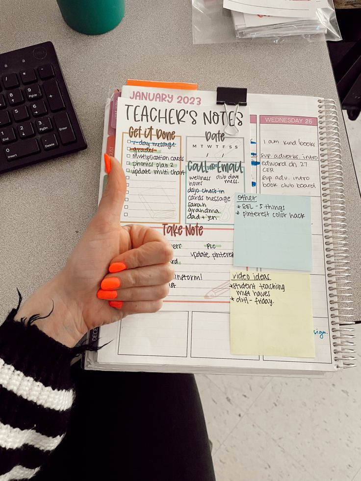 a woman is holding a notebook with notes on it and pointing to the page in front of her