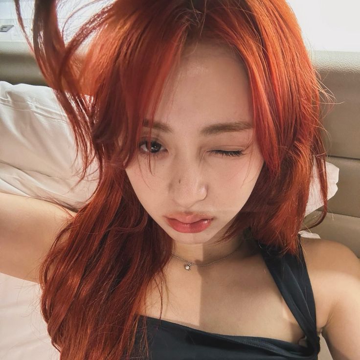 a woman with red hair laying in bed