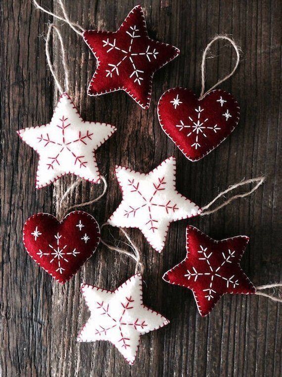 some red and white ornaments are hanging on a wooden table with string in the shape of snowflakes