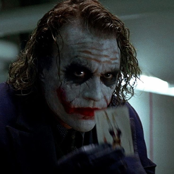 the joker is holding a piece of paper in his hand