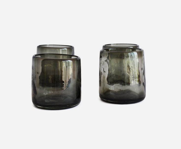 two gray glass jars sitting next to each other