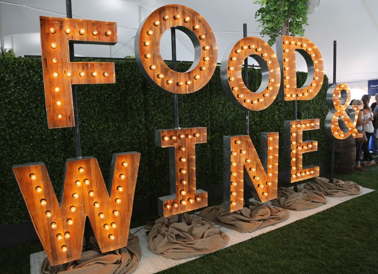 the food and wine festival is set up in front of a wall with large letters