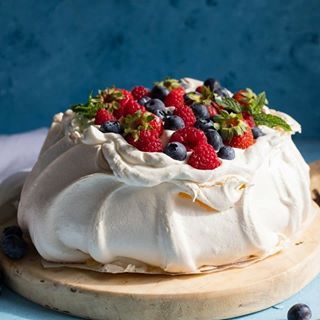 the best pavlova recipe with fresh berries and blueberries in it on a cutting board