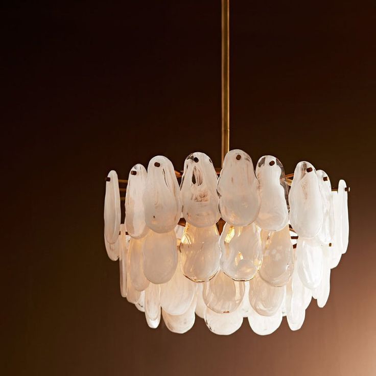 Experience the timeless beauty and sophistication of the Leon Chandelier from Arteriors. Featuring three tiers of white glazed glass plates, each with its own unique finish, and a matching glass cover over an antique brass canopy. This three-light chandelier is a true statement piece that combines striking finishes and organic forms. Perfect for any elegant setting, it is damp-rated but can also add a touch of luxury to bathrooms and well-covered outdoor spaces. Highlights Provides softly diffused ambient light Includes 120 in of SVT cord in Clear/Silver color Damp rated for use in bathrooms and covered patios Some assembly required Available in Antique Brass finish with White Marbled plates Arteriors Leon Chandelier in White/Gold Glazed Glass, Arteriors Home, Luxury Chandelier, Organic Forms, Outdoor Table Lamps, Oval Rugs, Glass Cover, Toilet Accessories, Organic Form