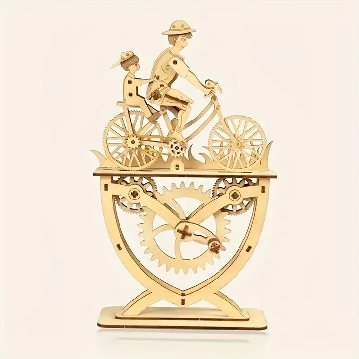 a golden clock with two people riding bicycles