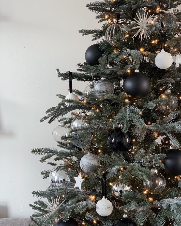 a decorated christmas tree with black and silver ornaments