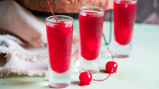 three glasses filled with red liquid and cherries