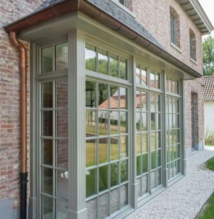 an image of a house that has windows on the side of it and grass in front