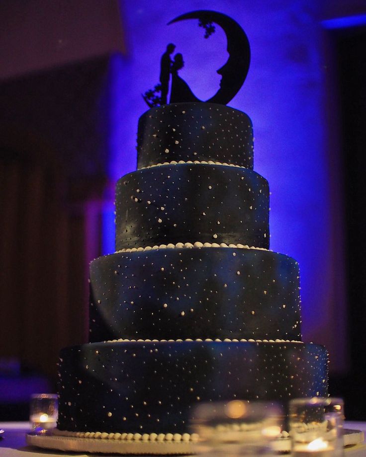 a black and white wedding cake with the moon on top