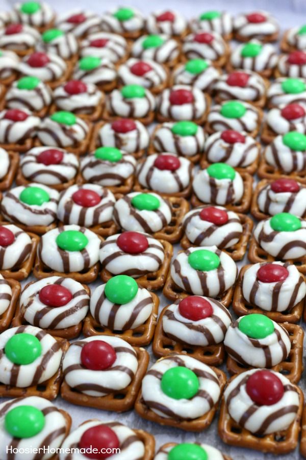 pretzel hugs with white and green candy on top, in the shape of christmas candies