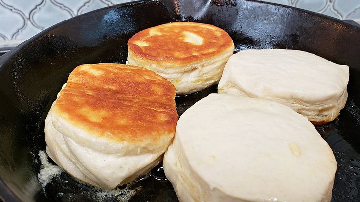 three pancakes cooking in a skillet on top of a stove