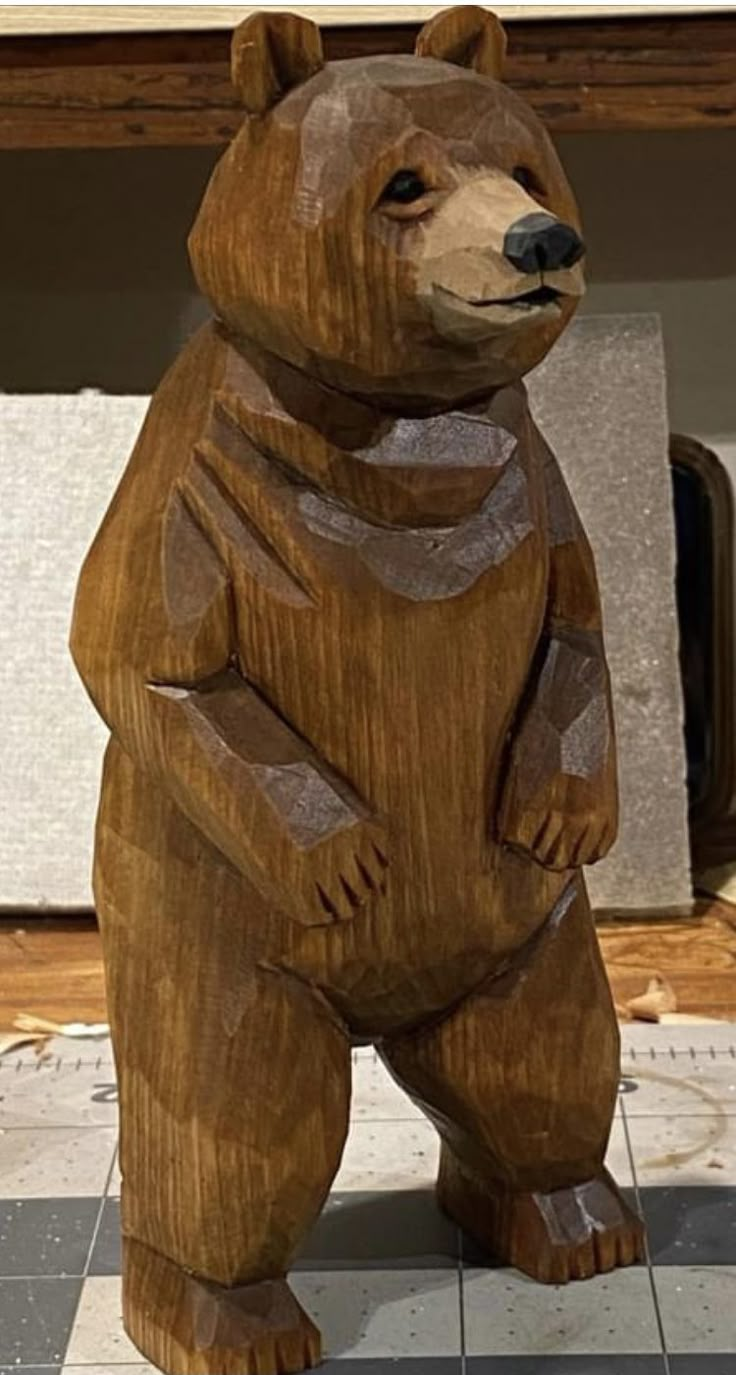 a wooden bear statue sitting on top of a tiled floor